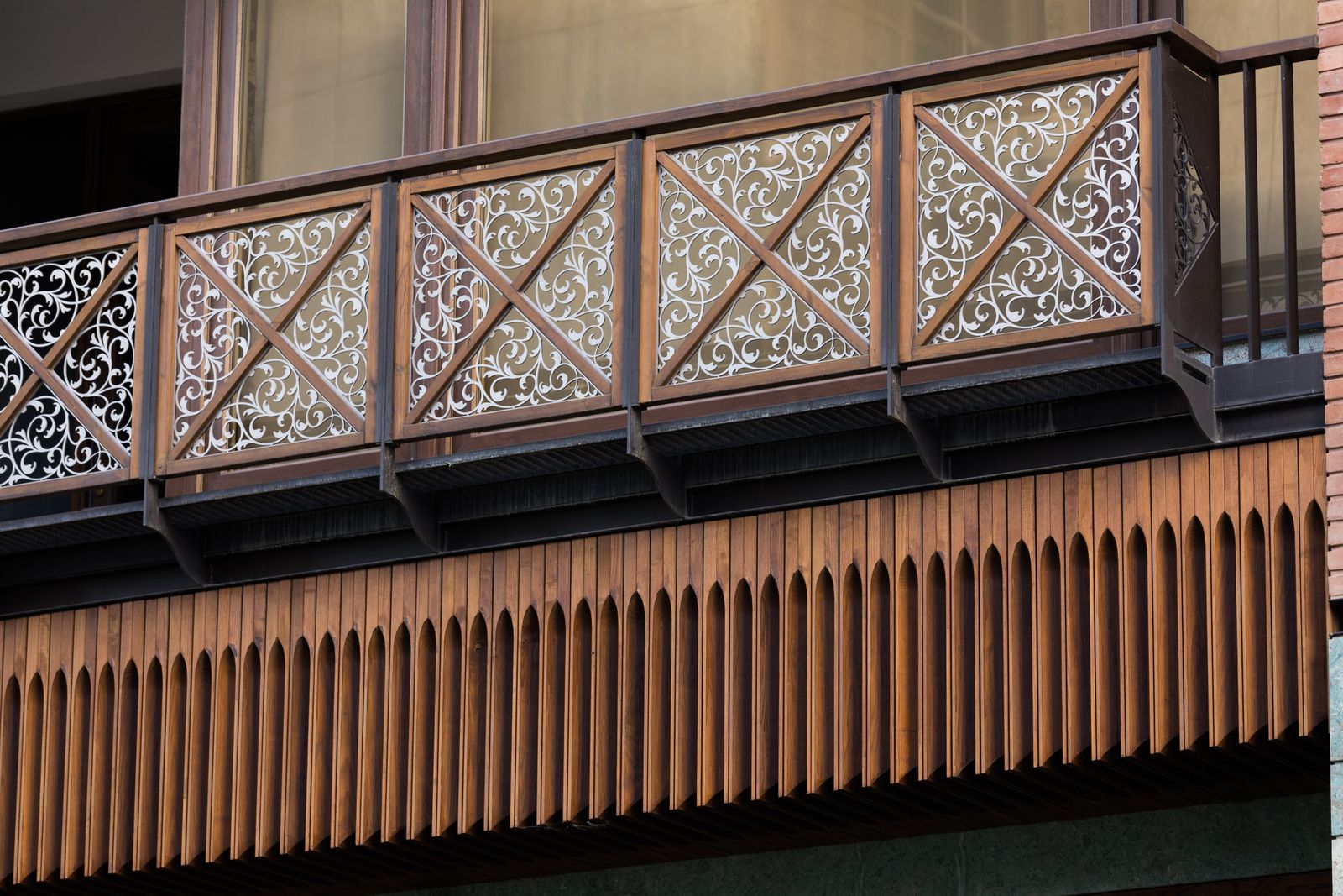Brick facade detail with timber cladding and patterned balcony screens