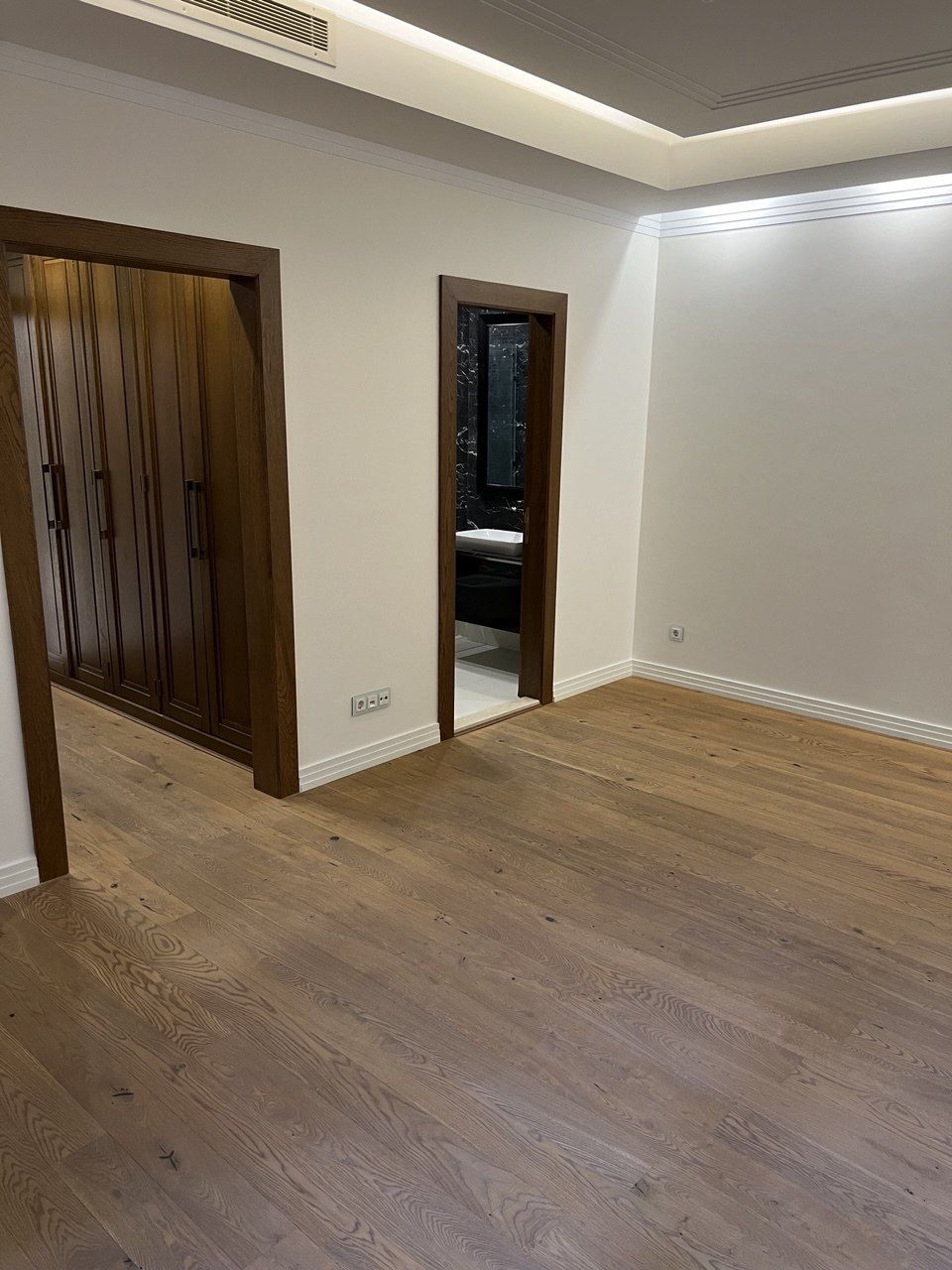 Finished room with wood flooring, recessed ceiling lighting and solid wood doors