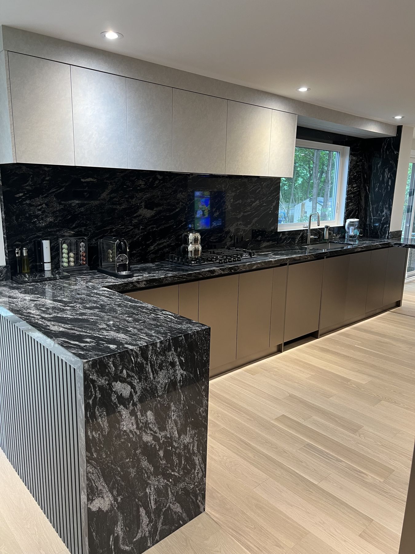 Finished kitchen with a dark stone island and flat-panel cabinets