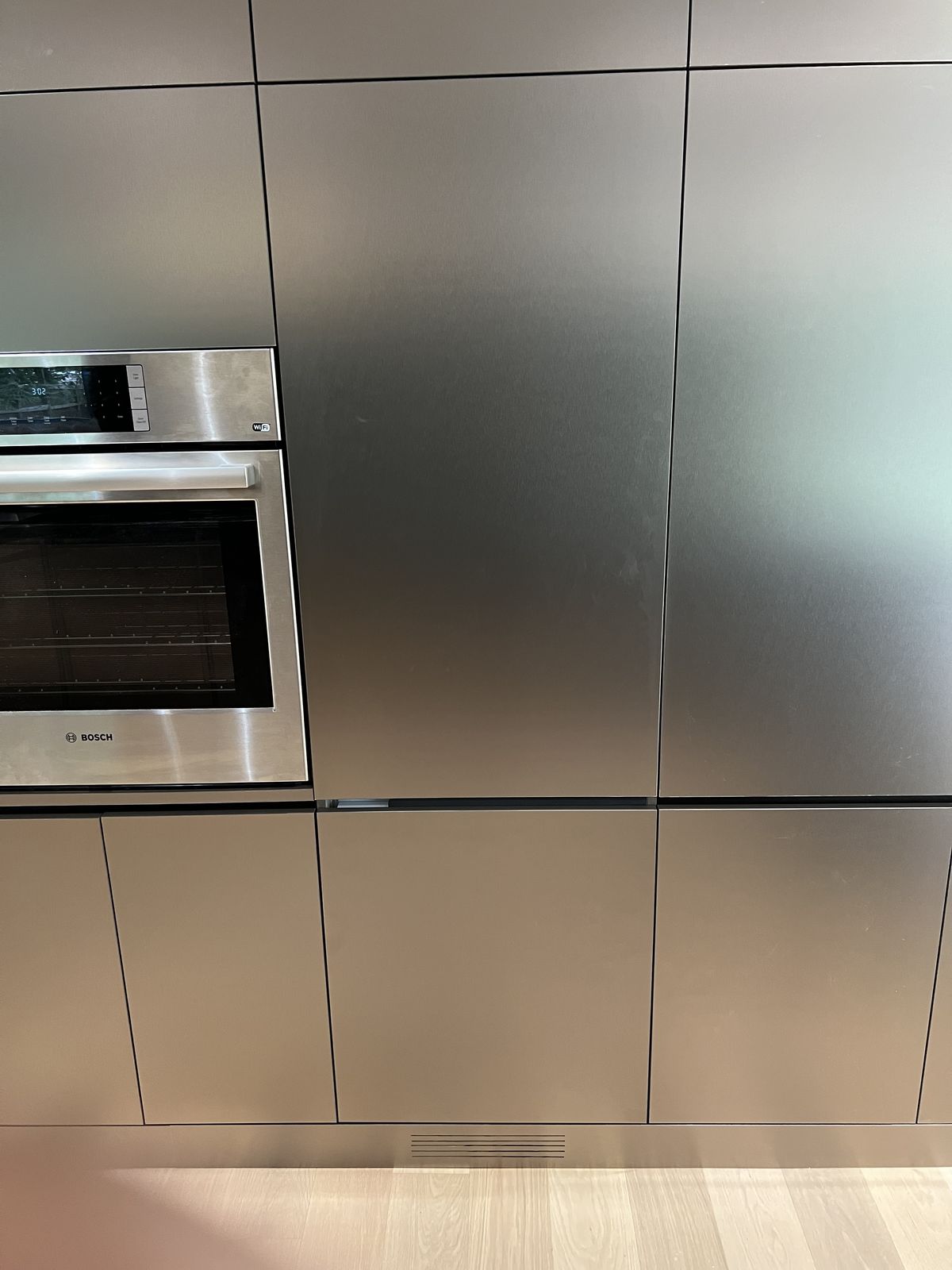 Floor-to-ceiling flat-panel cabinetry with an integrated wall oven
