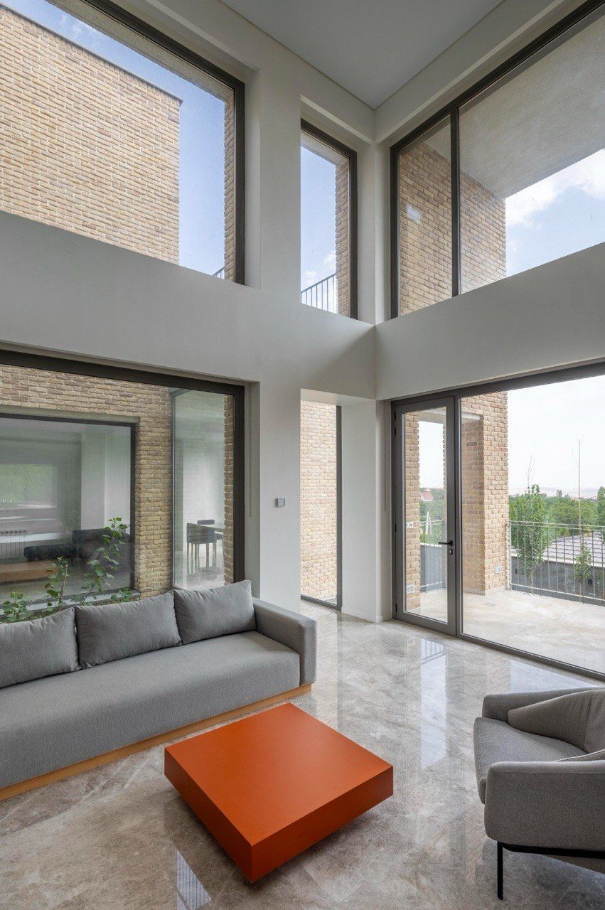 Double-height living room with full-height windows on two sides